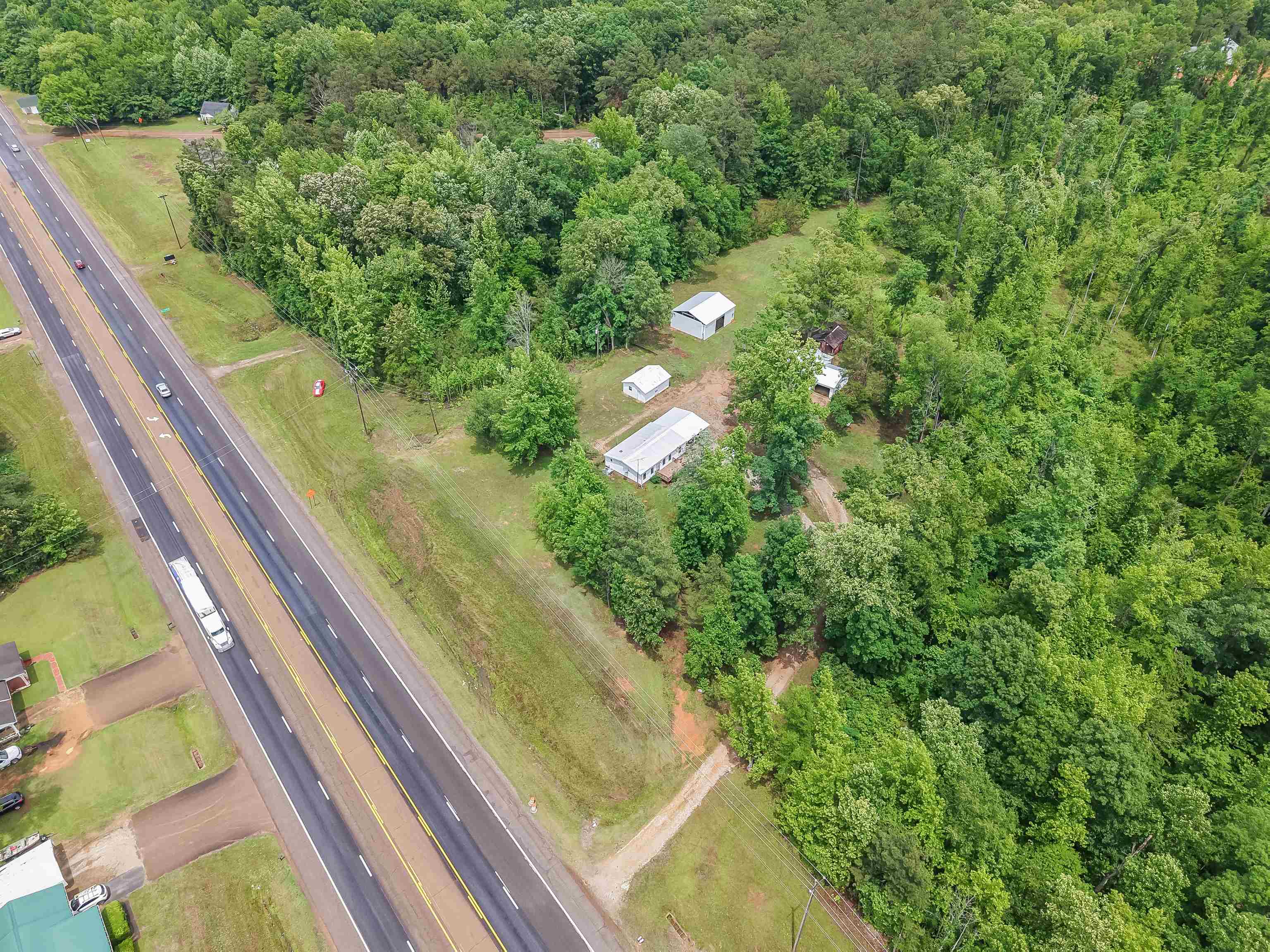 6264 45th Highway South Ramer, TN 38367 - Photo 9 of 24 Extensive wooded acreage with multiple outbuildings and direct road frontage