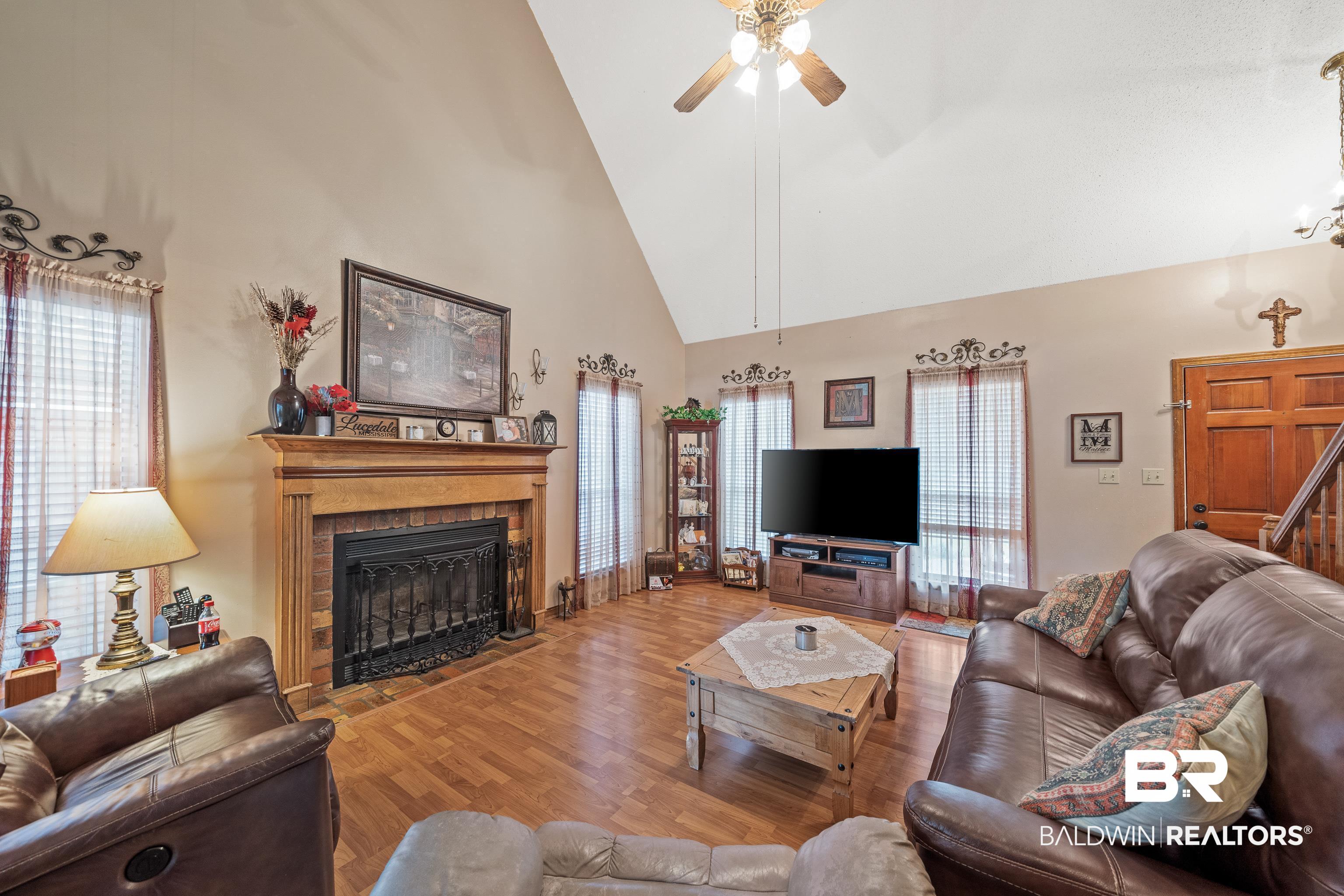 460 Ridgewood Drive Daphne, AL 36526 - Photo 3 of 31 Living room featuring ceiling fan, hardwood / wood-style flooring, high vaulted ceiling, and a healthy amount of sunlight
