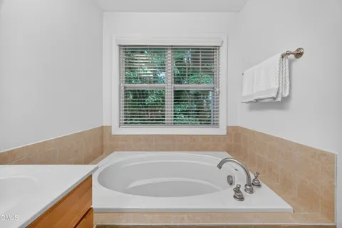 a bathroom with bathtub and window