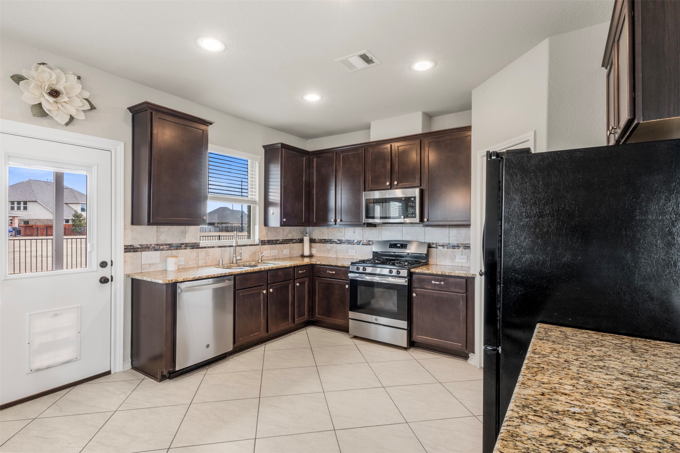 6210 Mason Way Rosenberg, TX 77471 - Photo 11 of 31 a kitchen with stainless steel appliances granite countertop a stove top oven a sink and dishwasher