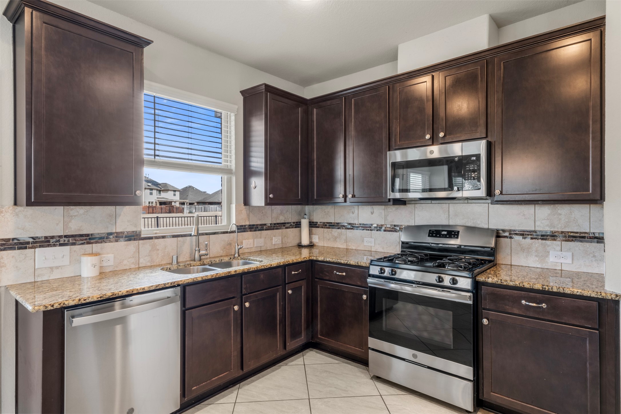 6210 Mason Way Rosenberg, TX 77471 - Photo 12 of 31 a kitchen with stainless steel appliances granite countertop a sink stove and microwave
