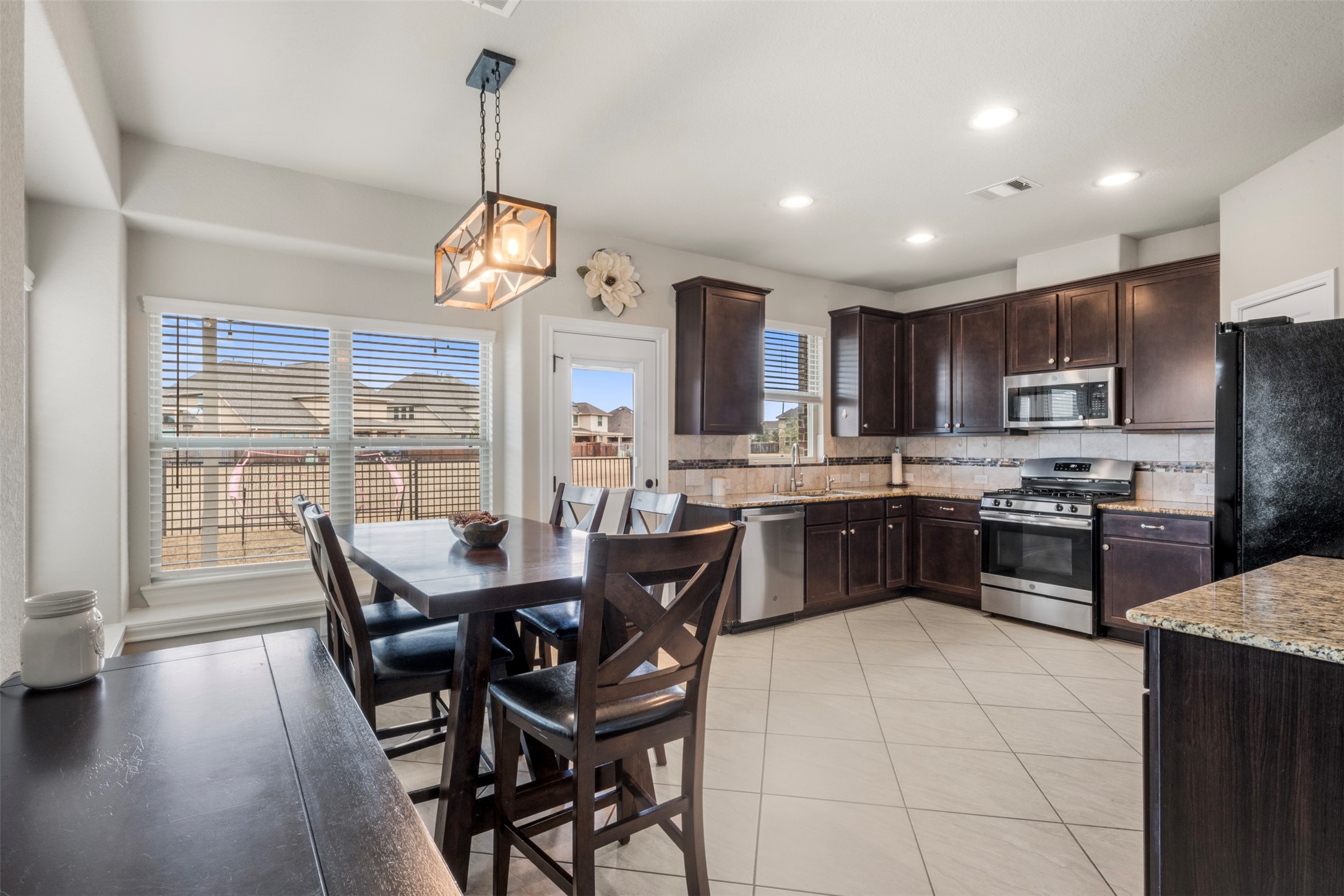 6210 Mason Way Rosenberg, TX 77471 - Photo 4 of 31 a kitchen with stainless steel appliances granite countertop a stove a kitchen island a sink dishwasher a dining table and chairs