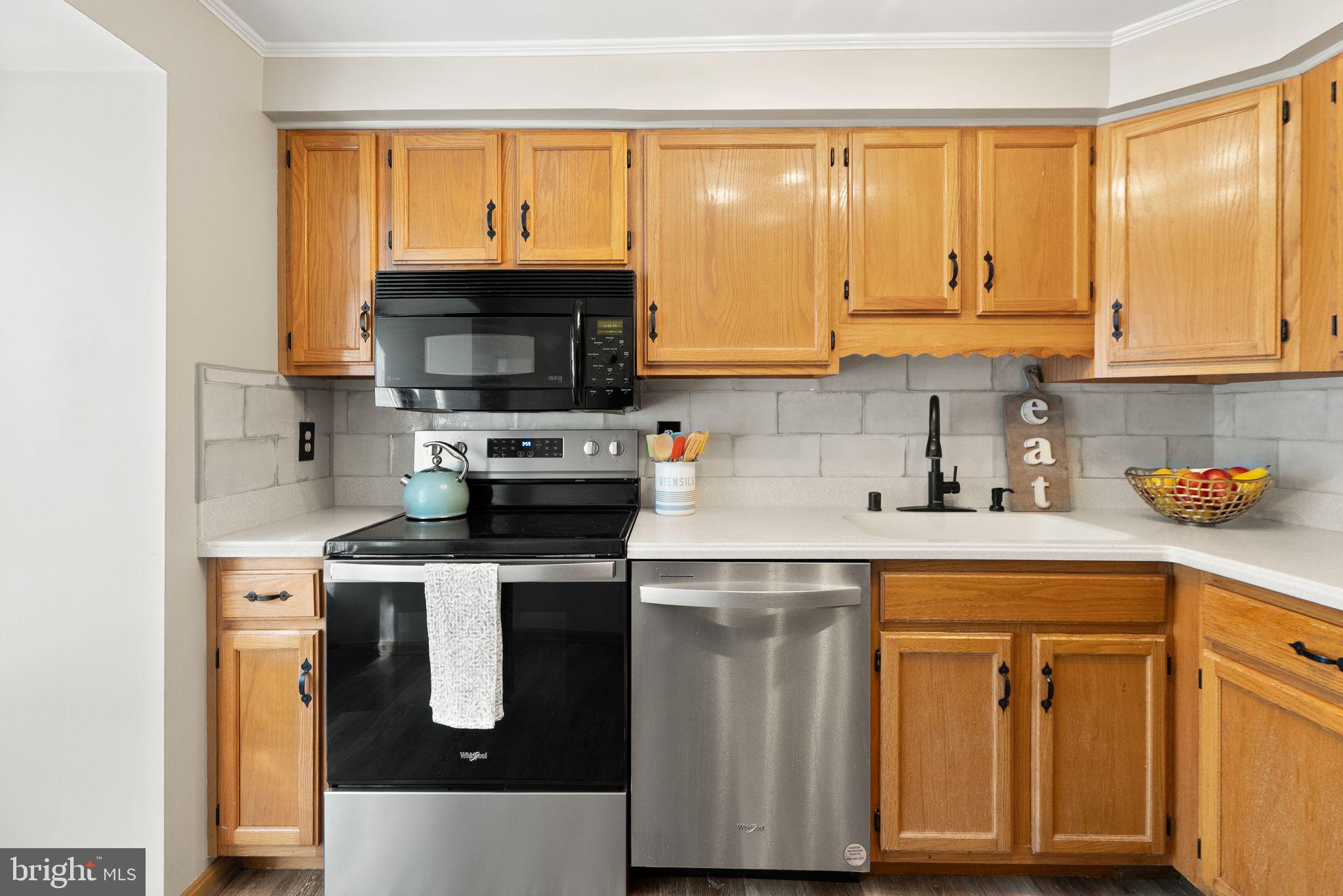 1700 Quietree Drive Reston, VA 20194 - Photo 28 of 76 a kitchen with stainless steel appliances granite countertop a stove a sink and a microwave