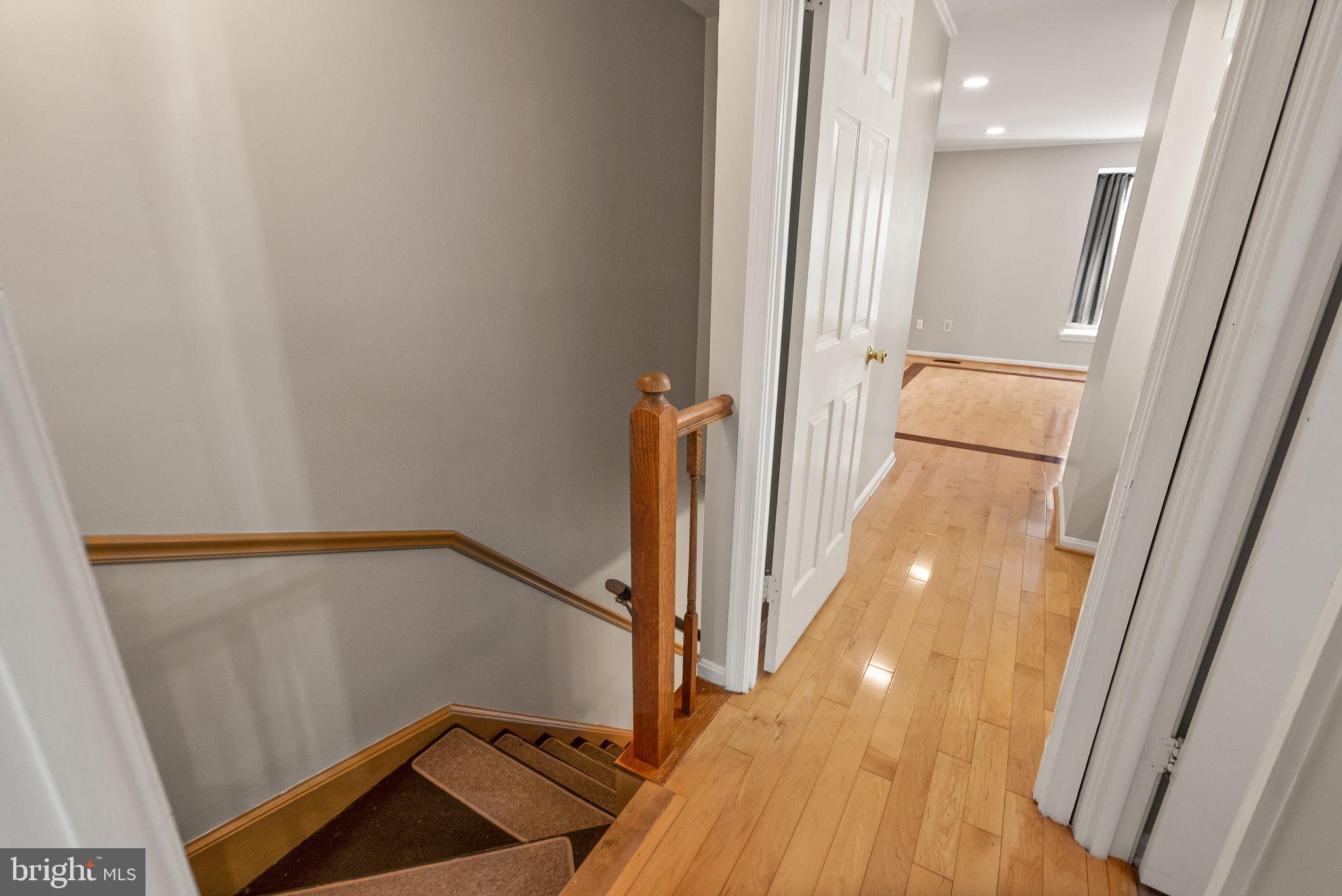 1700 Quietree Drive Reston, VA 20194 - Photo 37 of 76 a view of a hallway with wooden floor and staircase
