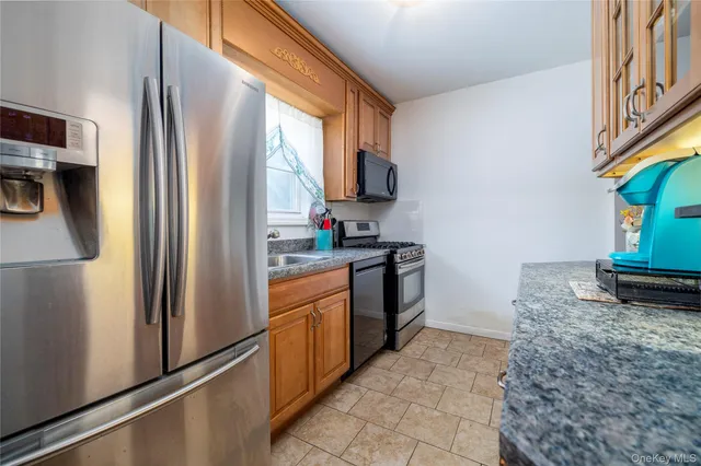 a kitchen with stainless steel appliances granite countertop a refrigerator a stove and a sink