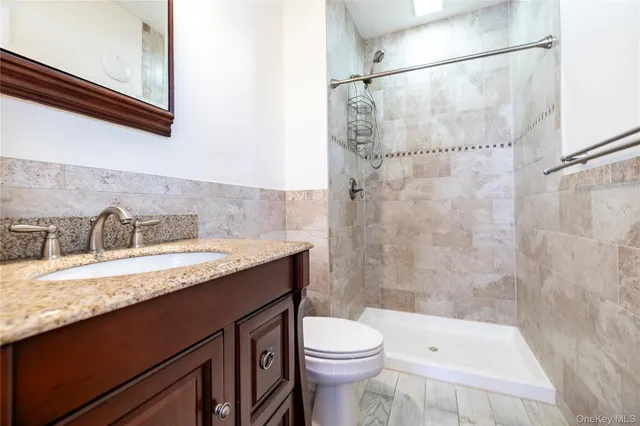 a bathroom with a granite countertop sink toilet and shower