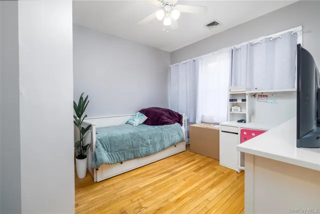 a bedroom with a bed and a potted plant