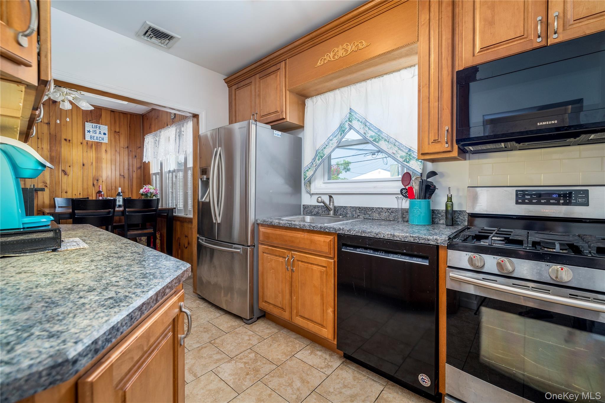 49 Barnes Street Long Beach, NY 11561 - Photo 10 of 30 a kitchen with stainless steel appliances granite countertop a sink stove and refrigerator