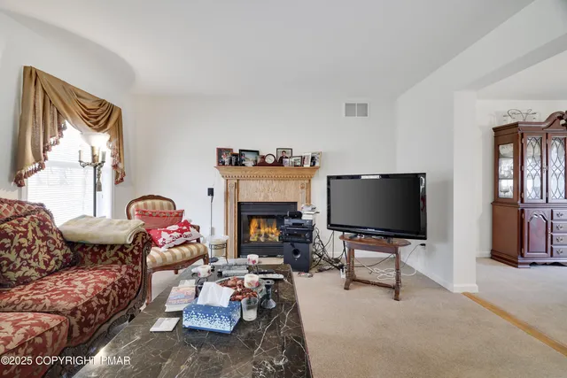 a living room with furniture a fireplace and a flat screen tv