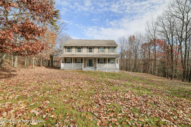 a view of residential houses with yard and trees