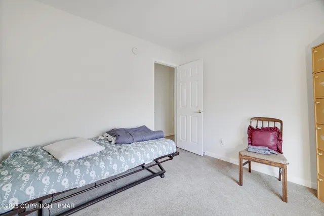 a bedroom with a bed chair and dresser