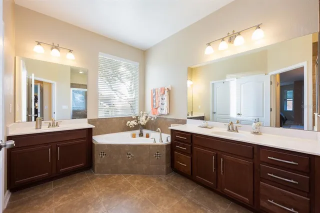 a bathroom with a shower sink double vanity and mirror