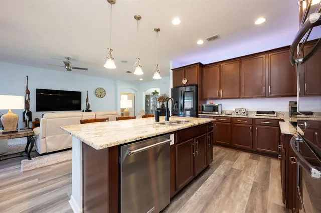 a kitchen with a sink a counter top space a stove and cabinets