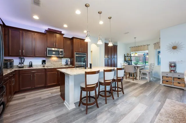 a kitchen with kitchen island granite countertop wooden floors and wooden cabinets