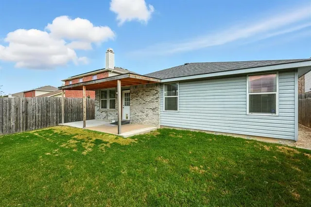 a backyard of a house with table and chairs