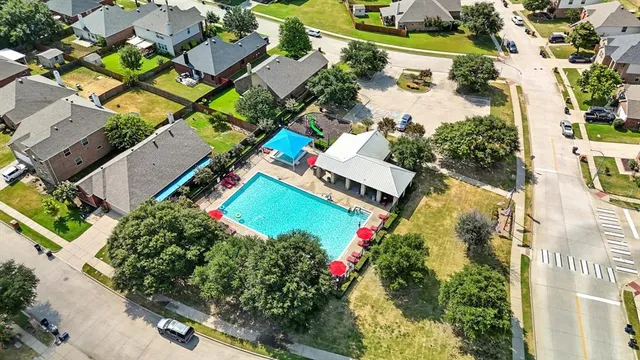 an aerial view of a house with a yard and tennis court