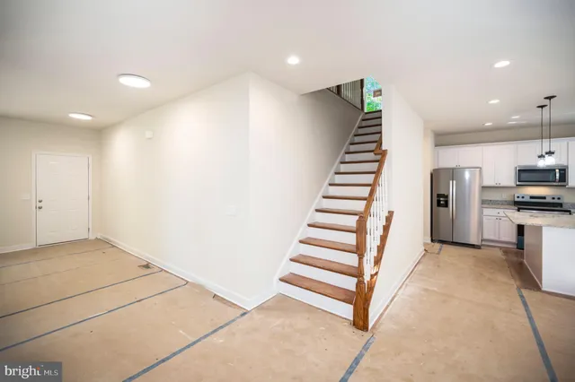 a kitchen with stainless steel appliances granite countertop a refrigerator and a stove top oven