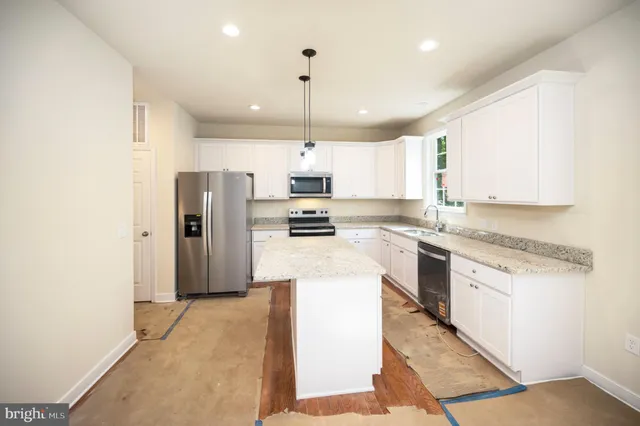 a kitchen with a refrigerator a stove top oven a sink and dishwasher
