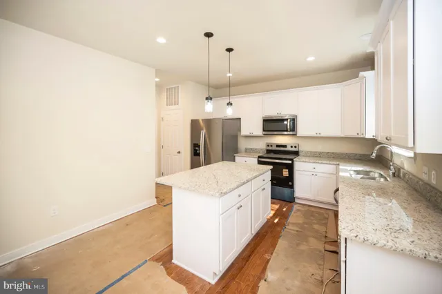 a kitchen with a sink a counter top space stainless steel appliances and cabinets