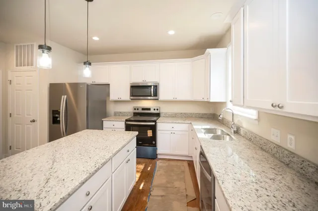 a kitchen with appliances a sink and cabinets