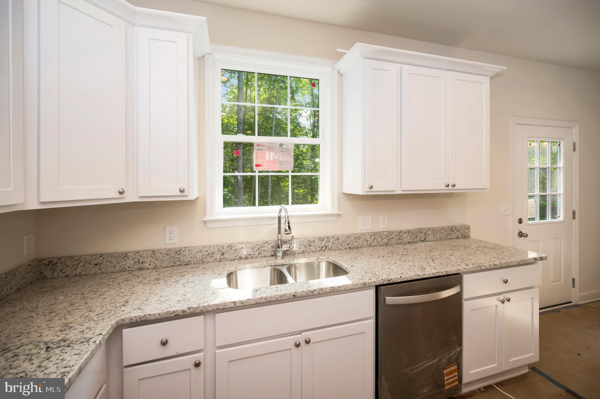 6077 Hamlin Circle King George, VA 22485 - Photo 29 of 50 a kitchen with granite countertop white cabinets and window