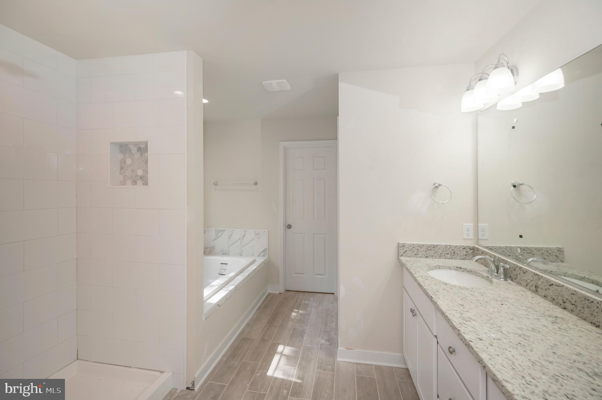 6077 Hamlin Circle King George, VA 22485 - Photo 33 of 50 a bathroom with a granite countertop sink two mirror and a bathtub