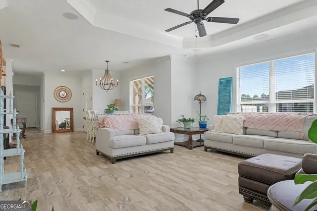 a living room with furniture a flat screen tv and kitchen view