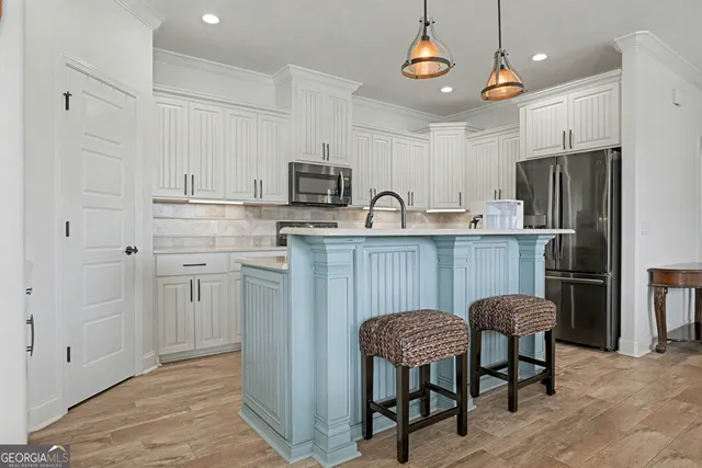 a kitchen with cabinets stainless steel appliances and a counter space