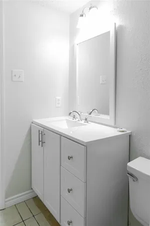 a bathroom with a sink vanity and a toilet