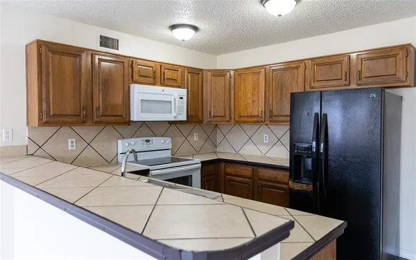 a kitchen with stainless steel appliances wooden cabinets a refrigerator and a sink