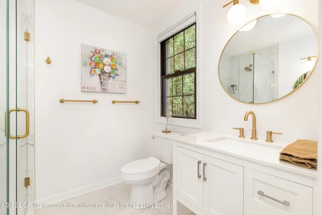 a bathroom with a toilet a sink a mirror and a window