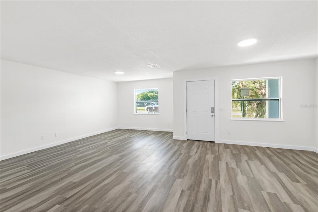 426 Bascom Court Polk City, FL 33868 - Photo 4 of 33 an empty room with wooden floor and windows