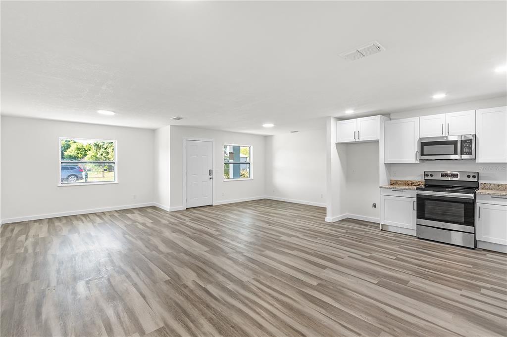 426 Bascom Court Polk City, FL 33868 - Photo 7 of 33 a view of kitchen with granite countertop stainless steel appliances and wooden floor