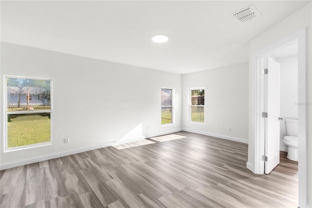 426 Bascom Court Polk City, FL 33868 - Photo 8 of 33 an empty room with wooden floor and windows