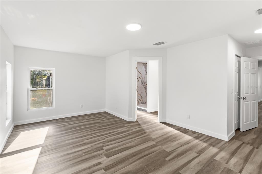 426 Bascom Court Polk City, FL 33868 - Photo 9 of 33 an empty room with wooden floor and windows