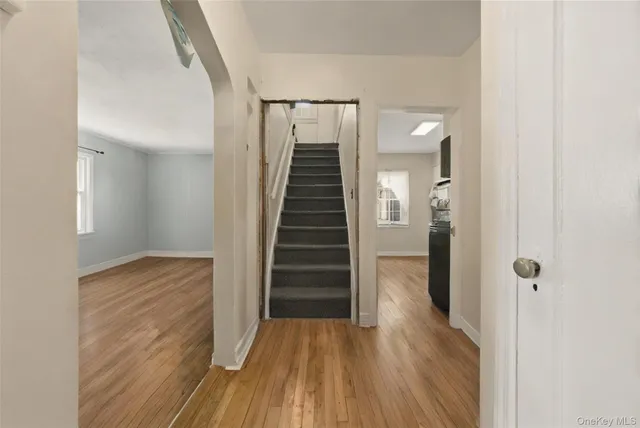 a view of hallway with stairs and wooden floor