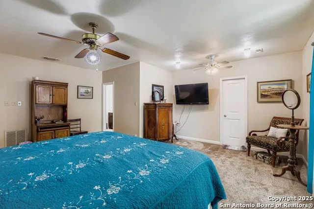 a bedroom with a bed and a flat tv screen on dresser