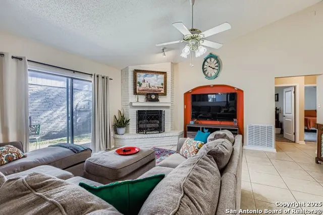 a living room with furniture a flat screen tv and a floor to ceiling window