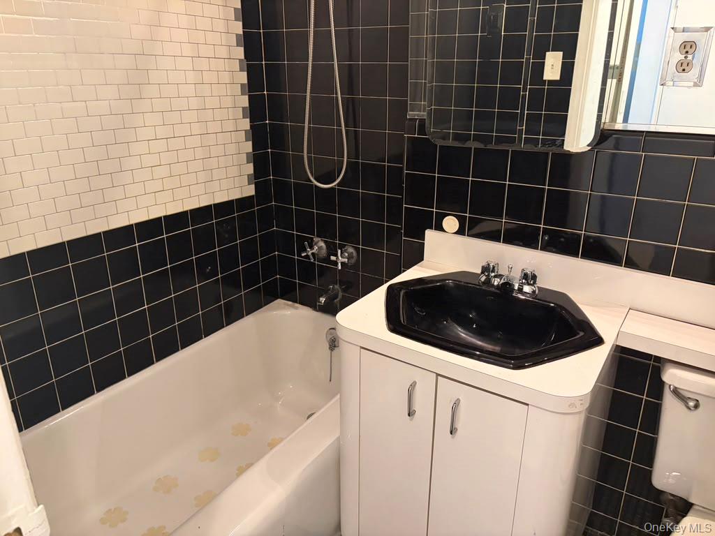 99-60 63rd Road, Unit 1H Queens, NY 11374 - Photo 8 of 11 a bathroom with a sink a toilet a shower and a mirror