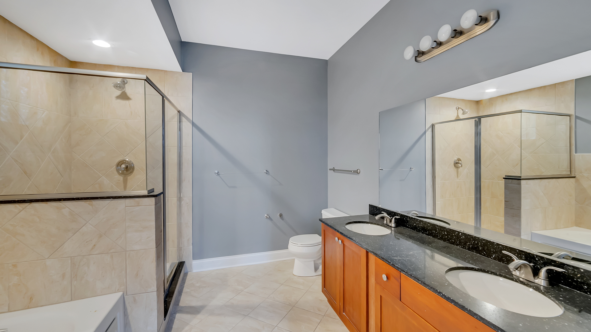 2417 West Fillmore Street, Unit 1 Chicago, IL 60612 - Photo 14 of 19 a bathroom with a granite countertop sink mirror vanity and shower