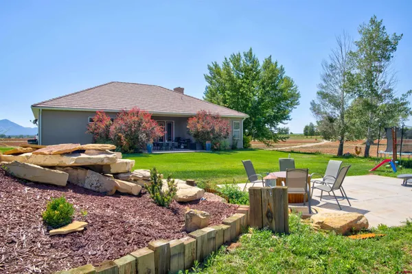 a view of backyard with outdoor seating and green space