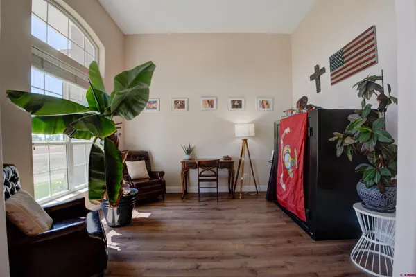 a living room with furniture a potted plant and a large window