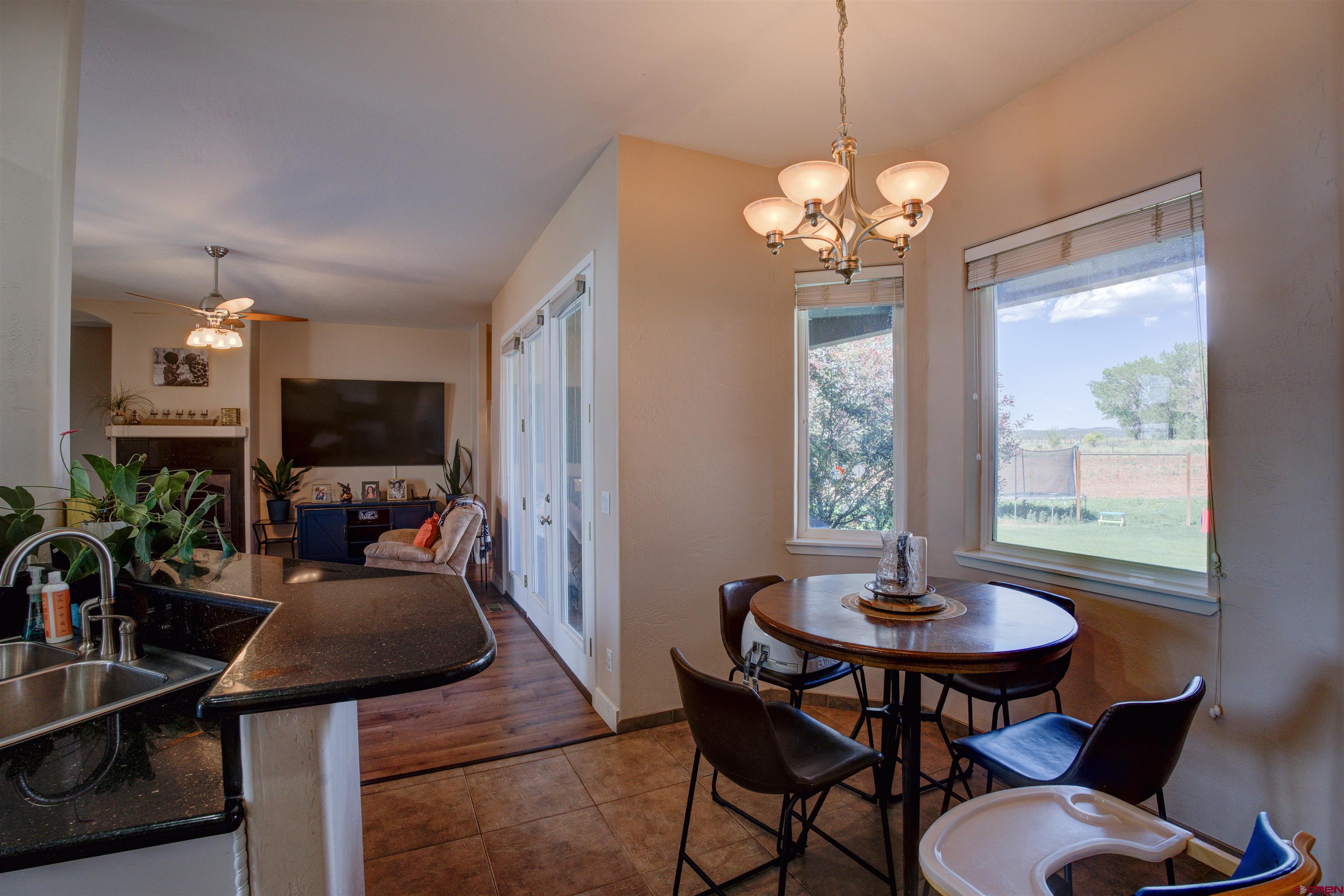 12868 Road 24.4 Loop Cortez, CO 81321 - Photo 10 of 28 a view of a dining room with furniture window and wooden floor