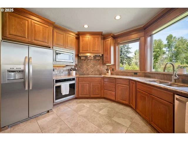 a kitchen with stainless steel appliances granite countertop a refrigerator sink and cabinets