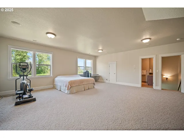 a bedroom with a bed and large windows
