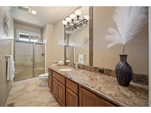 a bathroom with a granite countertop sink a mirror and a shower