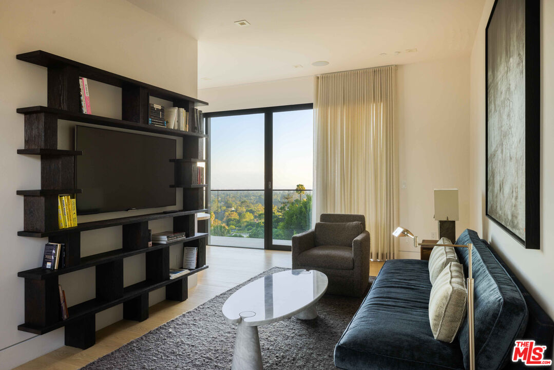 815 North Tigertail Road Los Angeles, CA 90049 - Photo 17 of 26 a living room with furniture a flat screen tv and a floor to ceiling window
