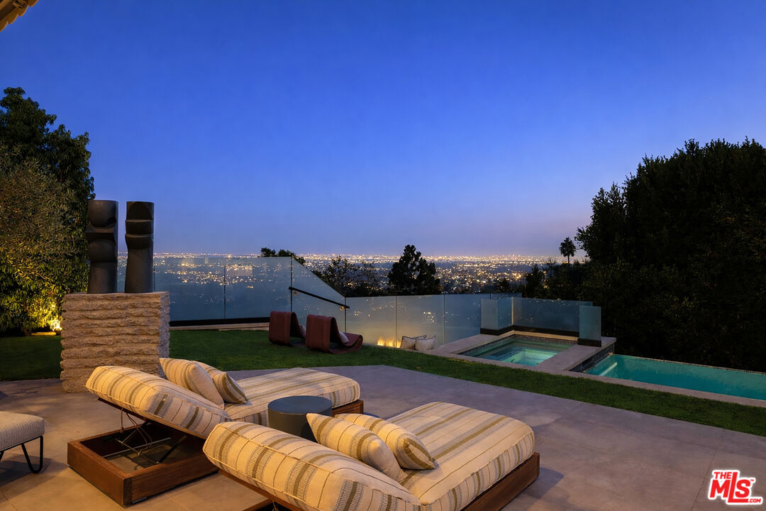 815 North Tigertail Road Los Angeles, CA 90049 - Photo 25 of 26 a view of a patio with couches chairs and a floor to ceiling window