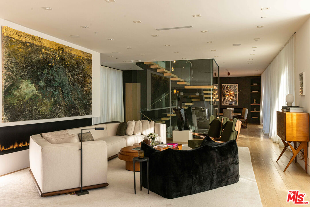 815 North Tigertail Road Los Angeles, CA 90049 - Photo 3 of 26 a living room with couches a flat tv screen and large closet with wooden floor