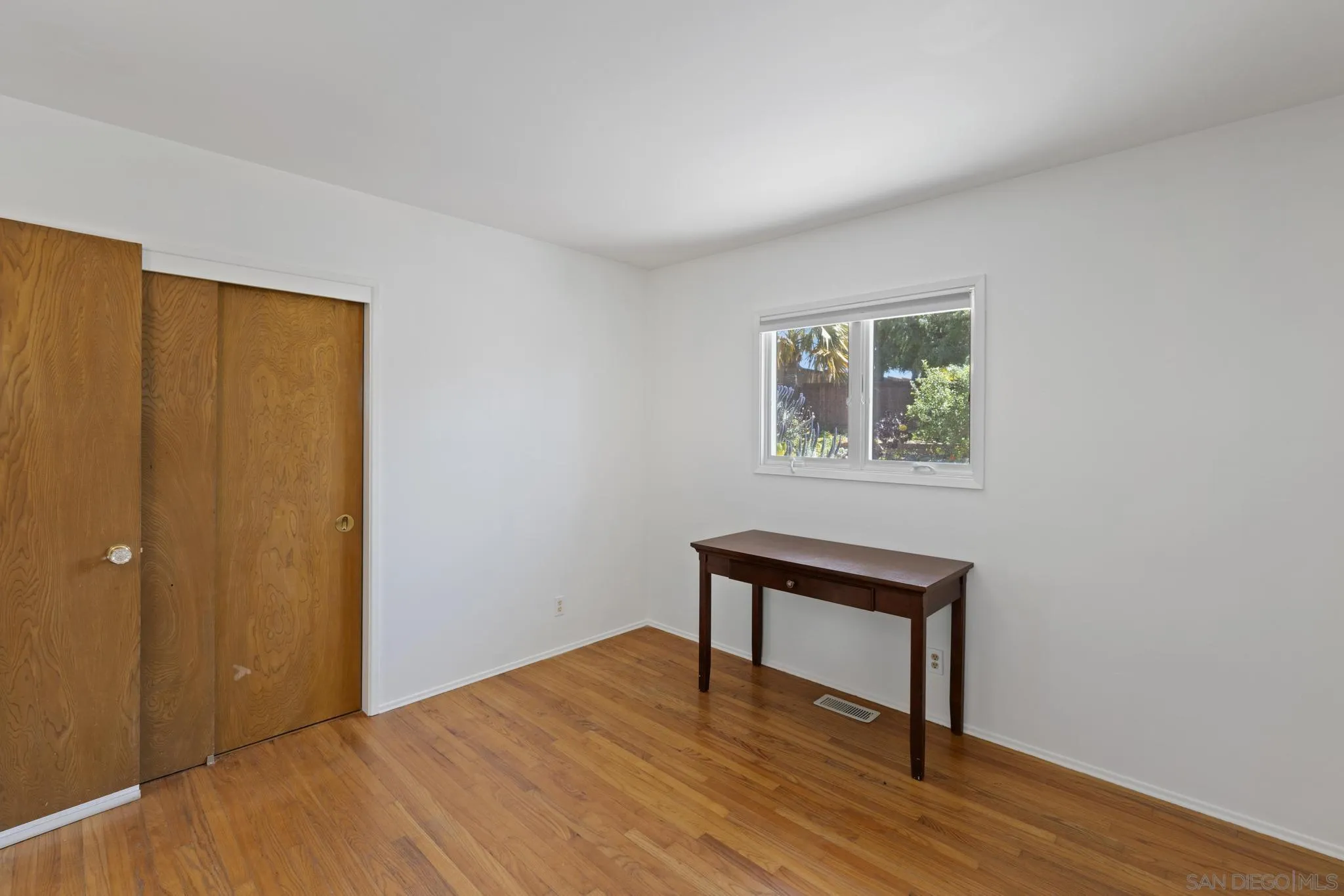 923 Sunset Drive Vista, CA 92081 - Photo 25 of 74 a view of an empty room with wooden floor and a window